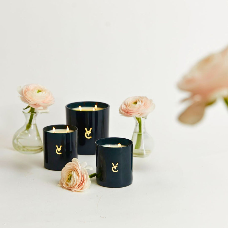 luxury scented candles in dark navy glass, striking design for display,  modern British luxury brand similar to Diptyque Baies candles